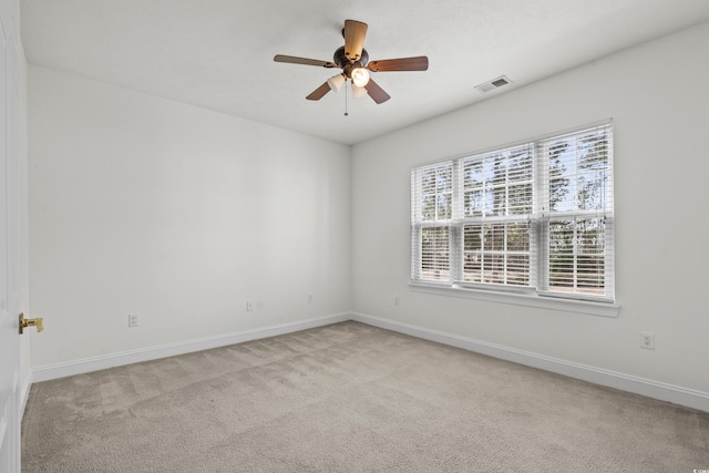 empty room with ceiling fan and light carpet