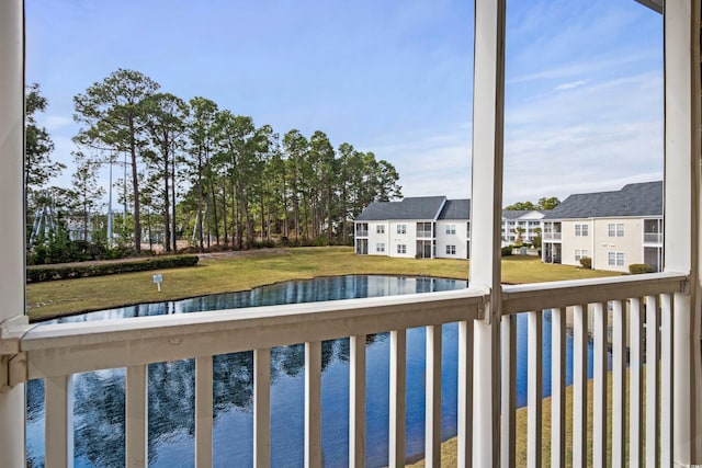 view of swimming pool with a water view and a lawn