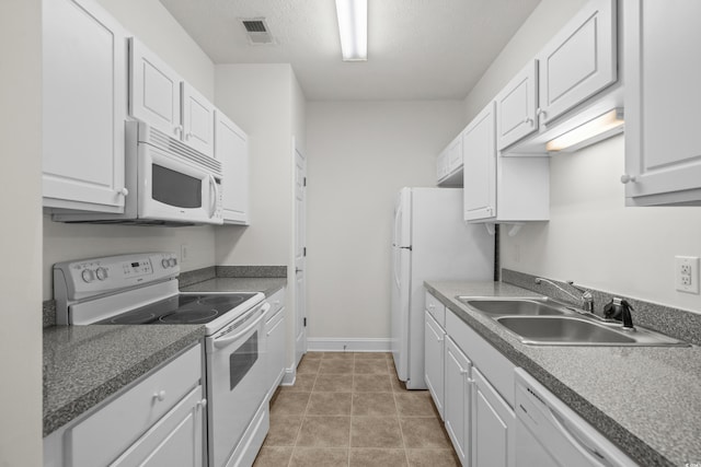 kitchen featuring sink, white cabinets, white appliances, tile patterned floors, and a textured ceiling