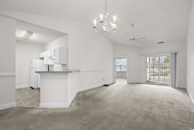 unfurnished living room featuring lofted ceiling, ceiling fan with notable chandelier, and light colored carpet