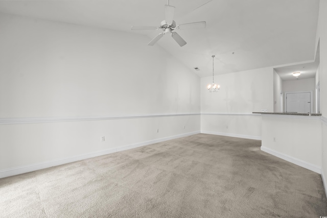 carpeted spare room with lofted ceiling and ceiling fan with notable chandelier