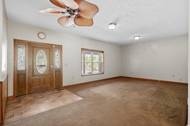 entrance foyer featuring light carpet, ceiling fan, and a textured ceiling