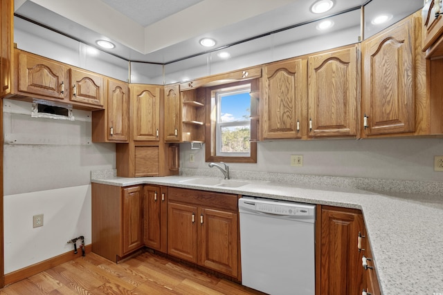 kitchen with white dishwasher, sink, and light hardwood / wood-style flooring