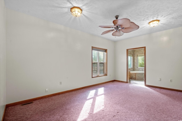 carpeted spare room with ceiling fan and a textured ceiling