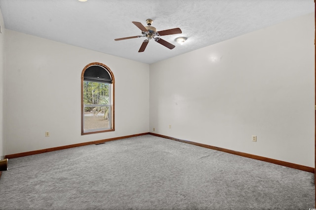 carpeted empty room with ceiling fan and a textured ceiling