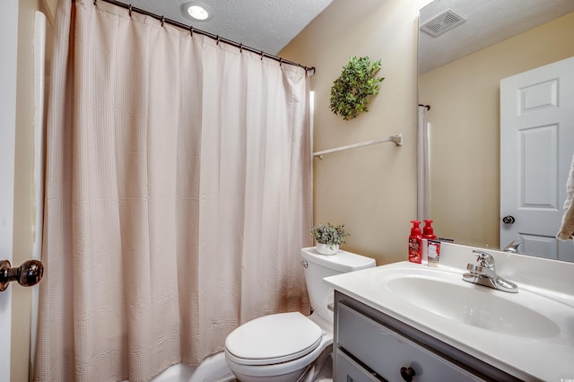 bathroom featuring vanity, curtained shower, toilet, and a textured ceiling