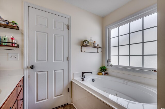 bathroom featuring a tub to relax in and vanity