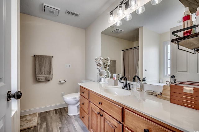 bathroom with vanity, hardwood / wood-style floors, and toilet