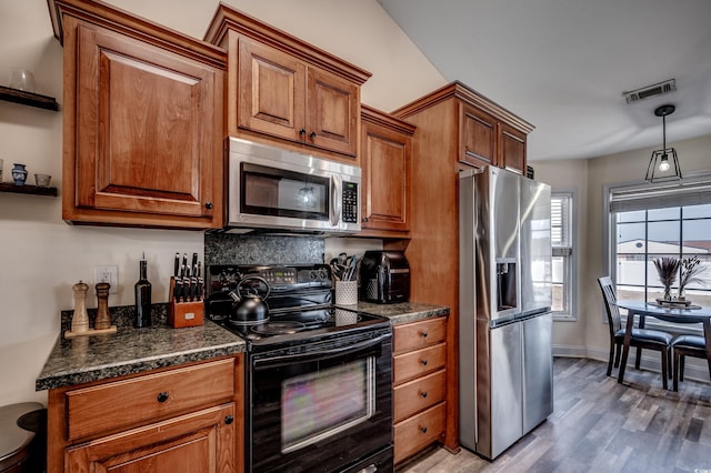 kitchen with stainless steel appliances, decorative light fixtures, and wood-type flooring