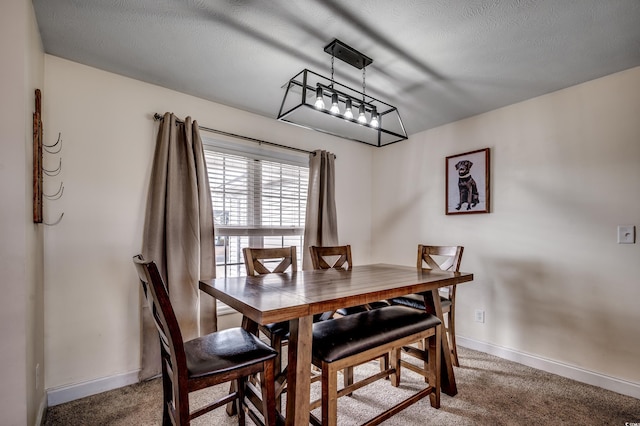 carpeted dining area featuring a textured ceiling