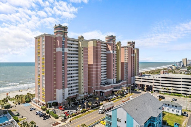 view of property with a water view and a beach view