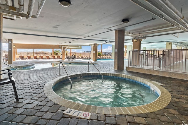 view of swimming pool with an indoor in ground hot tub and a patio area