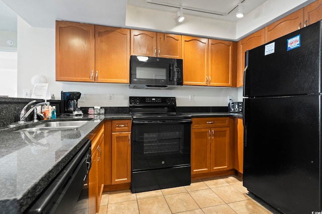 kitchen with light tile patterned flooring, dark stone counters, sink, and black appliances