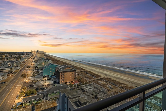 aerial view at dusk featuring a beach view and a water view