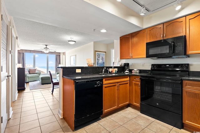 kitchen with light tile patterned flooring, sink, a textured ceiling, kitchen peninsula, and black appliances