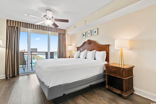 bedroom with ceiling fan, access to exterior, dark hardwood / wood-style flooring, and a textured ceiling