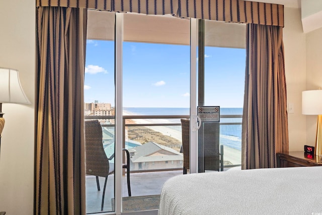 bedroom featuring a beach view and a water view