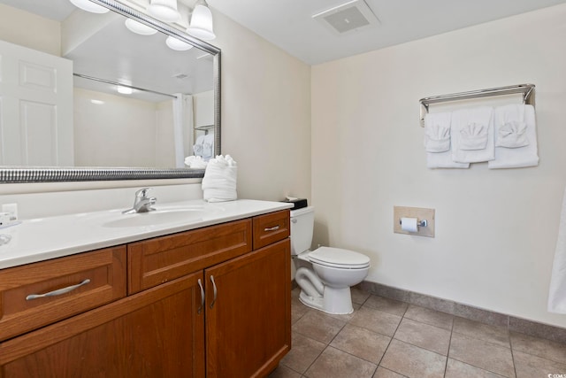 bathroom featuring vanity, tile patterned floors, and toilet