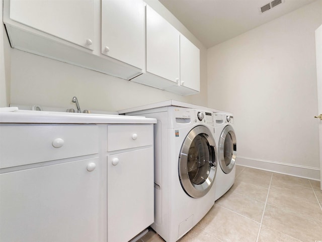 washroom with independent washer and dryer, cabinets, sink, and light tile patterned floors