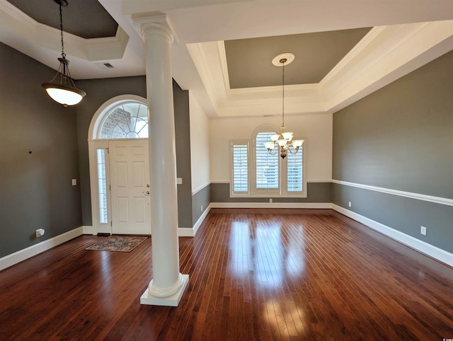 entryway featuring a tray ceiling, decorative columns, and a healthy amount of sunlight