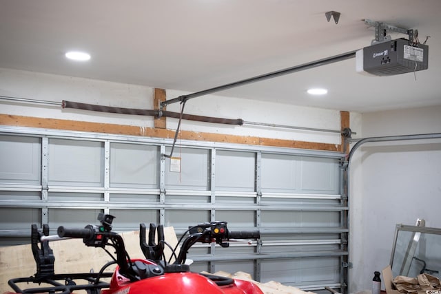 garage with a garage door opener and recessed lighting