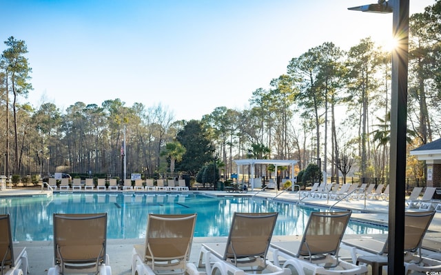 pool with fence, a pergola, and a patio