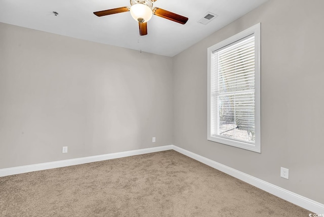 spare room featuring light carpet and ceiling fan