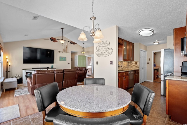 dining room with lofted ceiling, a textured ceiling, and an inviting chandelier