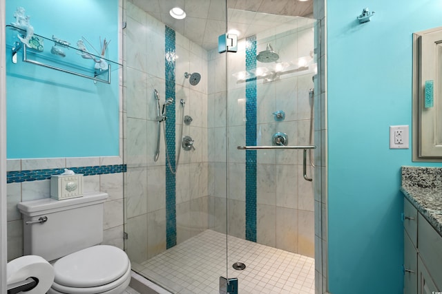 bathroom featuring vanity, a shower with door, tile walls, and toilet