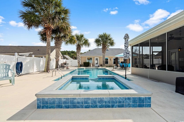 view of pool with a sunroom, a patio, and an in ground hot tub