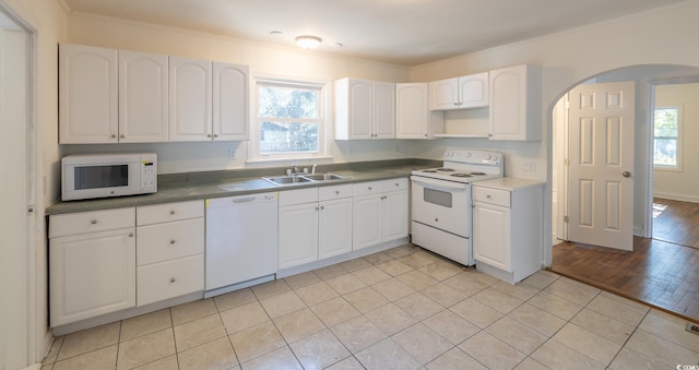 kitchen featuring white cabinetry, sink, and white appliances