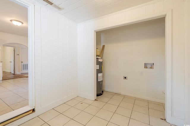 clothes washing area featuring light tile patterned floors, washer hookup, electric water heater, and electric dryer hookup