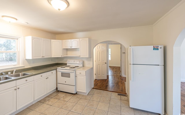 kitchen featuring light tile patterned flooring, sink, white cabinets, crown molding, and white appliances