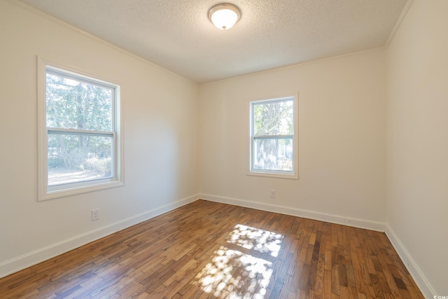 empty room featuring hardwood / wood-style flooring, crown molding, and a textured ceiling