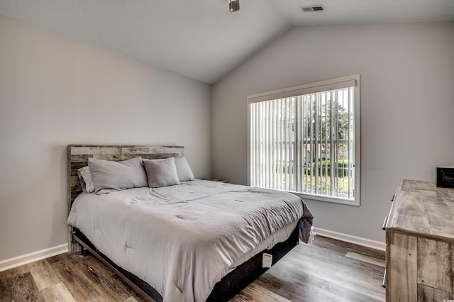 bedroom with lofted ceiling and hardwood / wood-style flooring