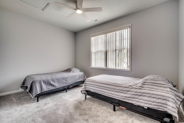 bedroom with ceiling fan, carpet floors, and a textured ceiling