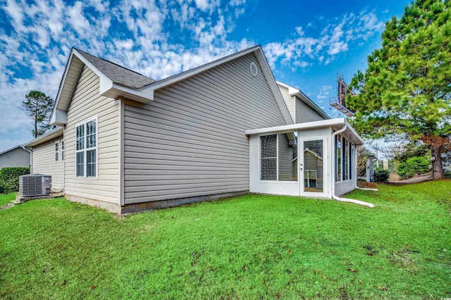 rear view of property featuring central AC, a yard, and a sunroom