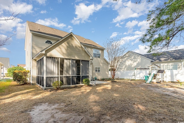 back of property featuring a sunroom and a playground