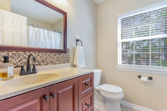 bathroom featuring vanity, toilet, tile patterned floors, and decorative backsplash