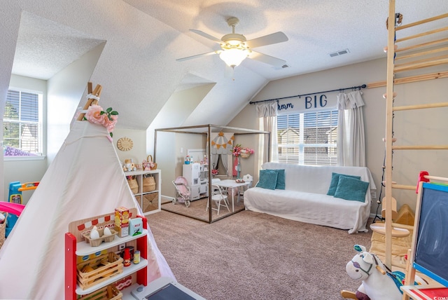 playroom featuring carpet, plenty of natural light, lofted ceiling, and a textured ceiling