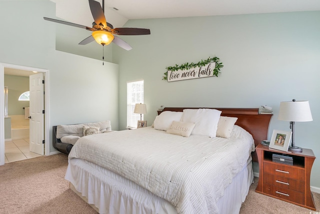 bedroom with multiple windows, ensuite bath, light carpet, and high vaulted ceiling