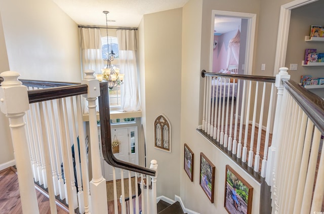 stairway with a notable chandelier, a towering ceiling, and hardwood / wood-style floors