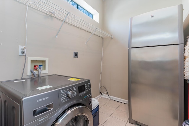 clothes washing area featuring washer / clothes dryer and light tile patterned flooring