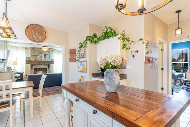 tiled dining area featuring a stone fireplace and a wealth of natural light