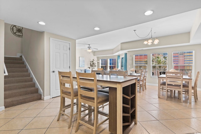 dining room with ceiling fan with notable chandelier and light tile patterned flooring