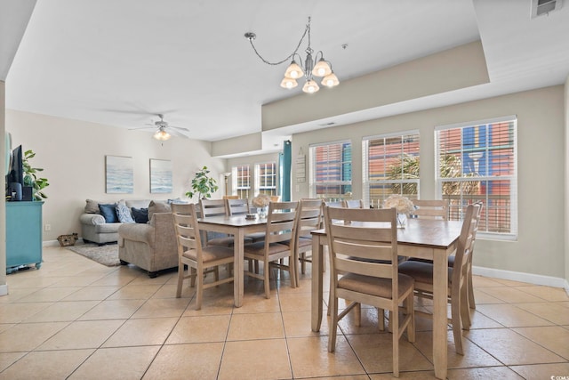 tiled dining room featuring ceiling fan with notable chandelier