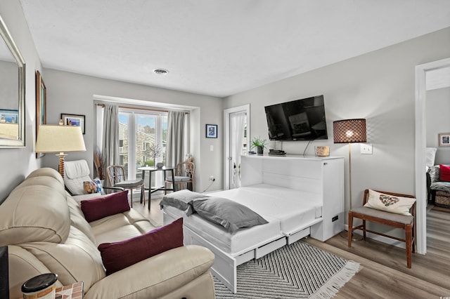 bedroom with access to exterior and light hardwood / wood-style flooring