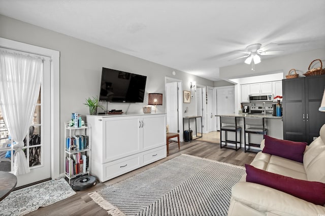 living room with ceiling fan and light wood-type flooring