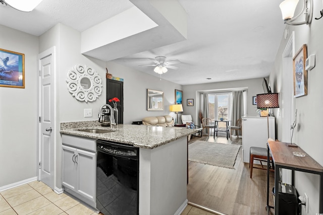 kitchen with sink, ceiling fan, white cabinetry, black dishwasher, and light stone counters