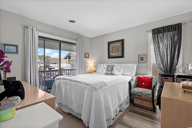 bedroom with access to exterior and light wood-type flooring